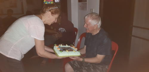Susie bringing a cake to Bill.