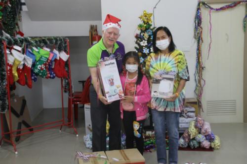 Bill giving gifts from Mountains Christian College to Nee and granddaughter.